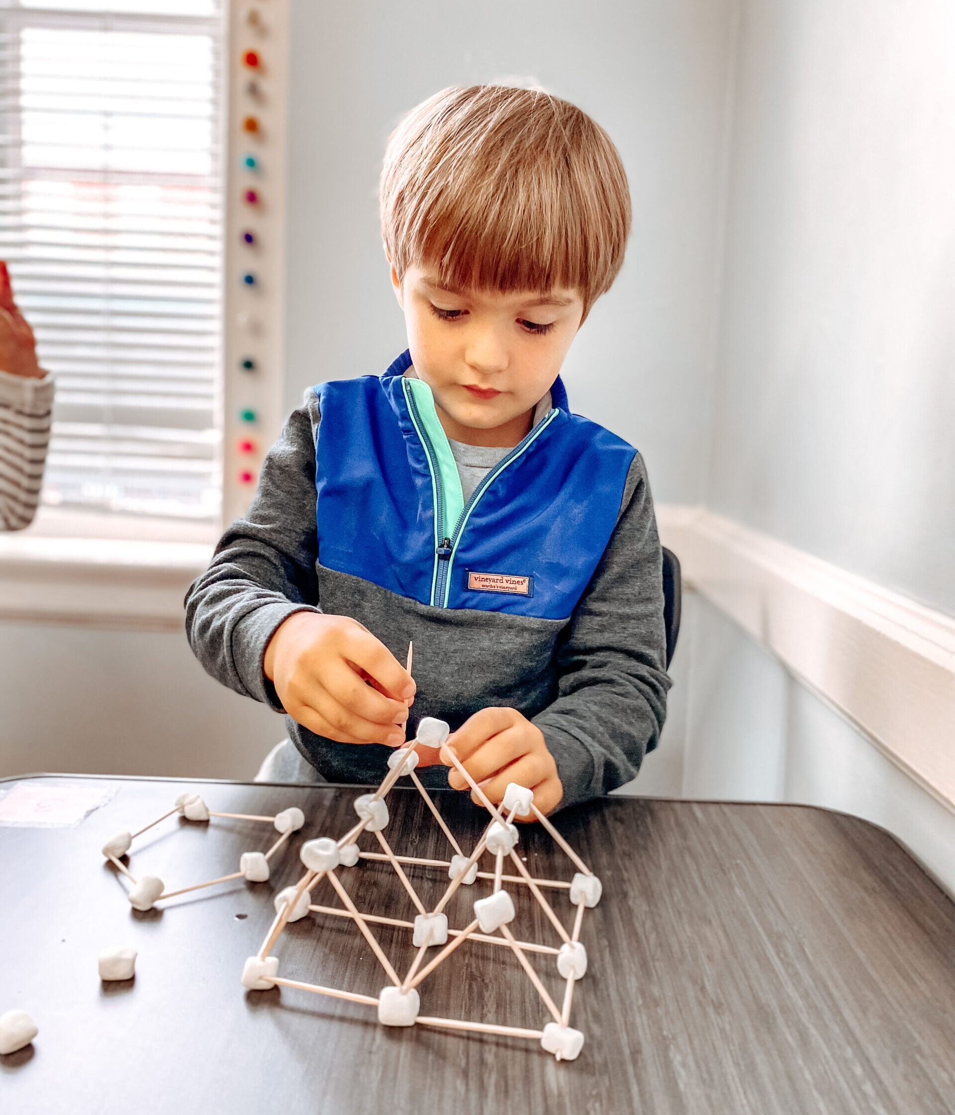 Kindergarten boy building with marshmellows and toothpicks for STEM activity